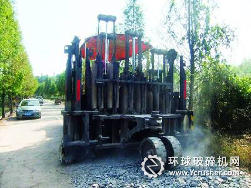 一臺大型多錘頭路面破碎機(jī)正在破碎水泥路面