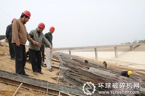 申振龍（左一）和總監(jiān)朱紹博一起檢查框格梁施工情況